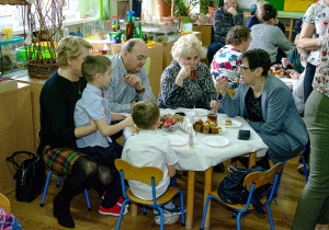 Dziadkowie i wnuczęta w trakcie słodkiego poczęstunku.